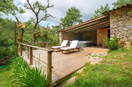 a wooden deck with two chairs and a table at Casa do Vale do Papo in Pombal