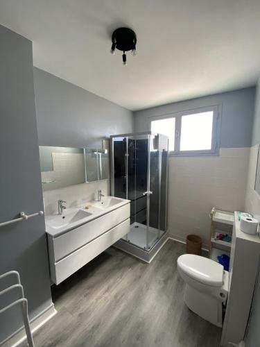 La salle de bains est pourvue d'un lavabo et de toilettes. dans l'établissement Maison familiale agréable proche plage et remblai - GARAGE, à Les Sables-dʼOlonne