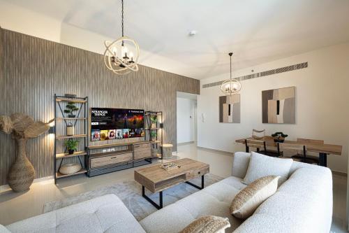 a living room with a couch and a tv at 2BHK Al Zahia Apartment, Sharjah - Boho Nest in Sharjah