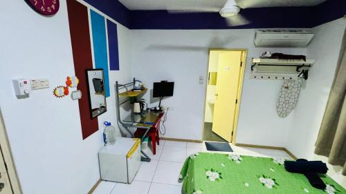 a bedroom with a green bed and a yellow door at Vista Alam Roomstay Homestay in Shah Alam