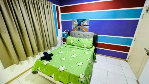 a bedroom with a green bed with flowers on it at Vista Alam Roomstay Homestay in Shah Alam