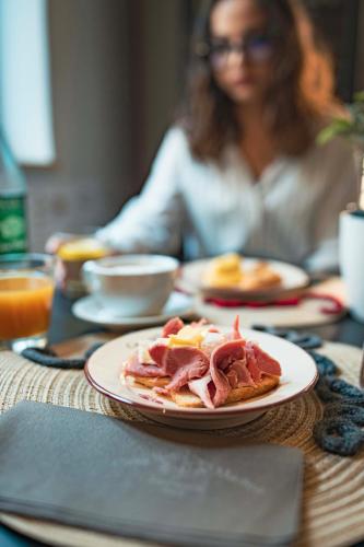 a woman sitting at a table with a plate of food at B&B Casa Madeo in San Demetrio Corone