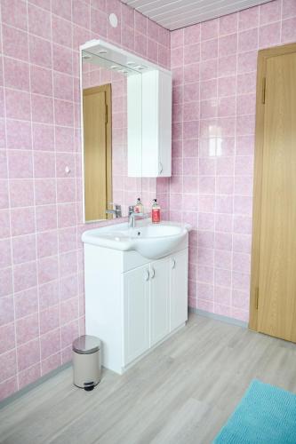 a bathroom with a sink and a mirror and pink tiles at Zimmervermietung Jäger in Bregenz