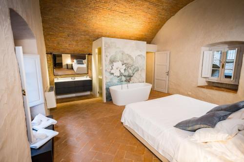 a bedroom with a large bed and a bath tub at Appartamento La Corte in Cortona