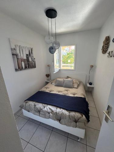 une chambre avec un lit dans une pièce blanche dans l'établissement Superbe 2pièces, proche plage de Grazel, et port, à Gruissan