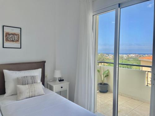 ein weißes Schlafzimmer mit Bett und Balkon in der Unterkunft Olea in the city in Gázion