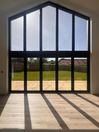 an empty room with a large window with a view of a field at Stylish & Spacious Getaway in Norwich
