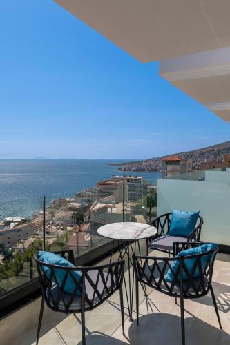 a table and chairs on a balcony with a view of the ocean at Litan Hotel in Sarandë
