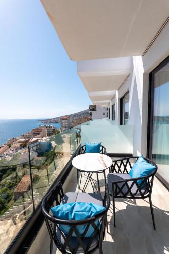 a balcony with a table and chairs and the ocean at Litan Hotel in Sarandë