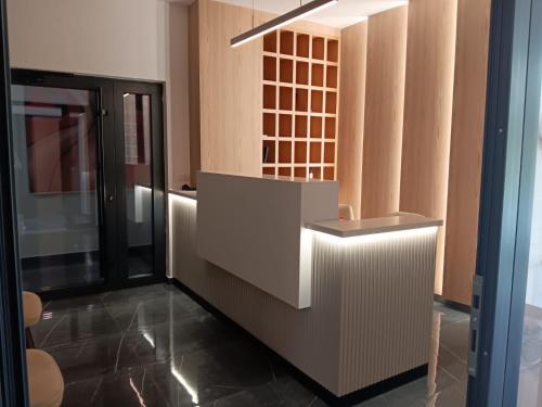 a kitchen with wooden cabinets and a glass door at Real Resort Albania in Fushë-Draç