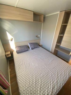 - une petite chambre avec un lit et des étagères dans l'établissement camping la marina, à Canet