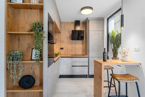 a kitchen with wooden walls and a table and stools at NEW Apartment Gironi with Pool, Jacuzzi in Tugare