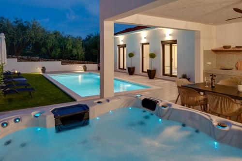 a swimming pool in a backyard with a table and chairs at NEW Apartment Gironi with Pool, Jacuzzi in Tugare