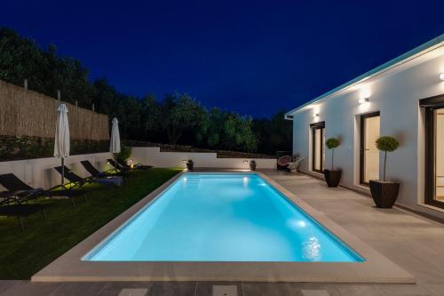 a swimming pool in the backyard of a house at night at NEW Apartment Gironi with Pool, Jacuzzi in Tugare