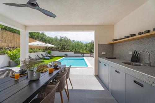 a kitchen with a table and a swimming pool at NEW Apartment Gironi with Pool, Jacuzzi in Tugare