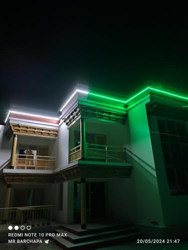 a building with green lights on top of it at Wachan Guest House -Hunder in Hundar