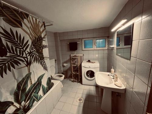 a bathroom with a sink and a washing machine at Neni's House in Prinos