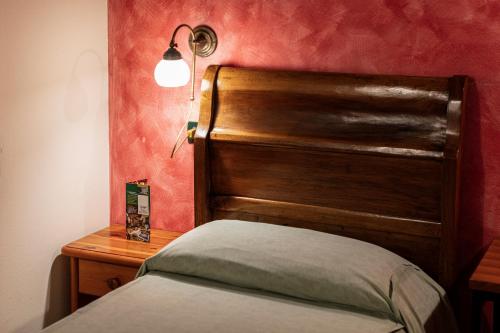 a bed with a wooden headboard in a room at Agriturismo Il Palazzone in Montegalda