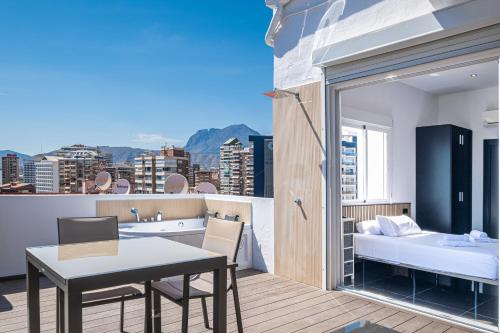 a room with a table and a bed on a balcony at Penthouse Cervantes Sea View Levante Beach in Benidorm
