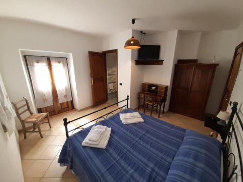 a bedroom with a blue bed with two towels on it at Casale del Gufo in Chiaravalle