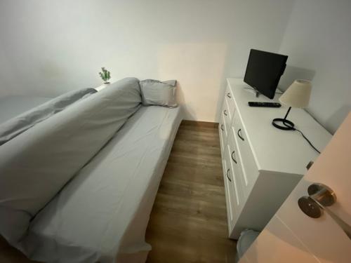 sypialnia z łóżkiem i biurkiem z laptopem w obiekcie Habitación privada Cerca Aeropuerto w Maladze