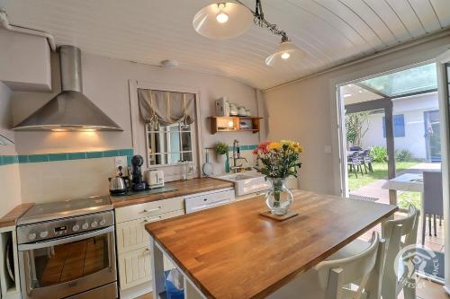 une cuisine avec une table avec un vase de fleurs dessus dans l'établissement Le petit cottage, à Saint-Malo