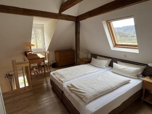 Schlafzimmer mit einem Bett, einem Fenster und einem Schreibtisch in der Unterkunft Mosel-Landhaus Hotel Oster in Ediger-Eller