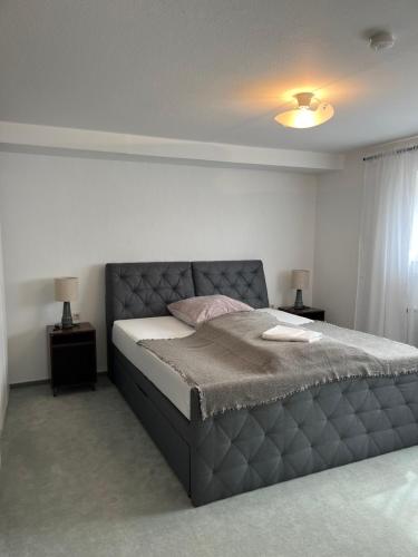 a bedroom with a bed and two nightstands and two lamps at Deluxe Apartment Ella in Backnang