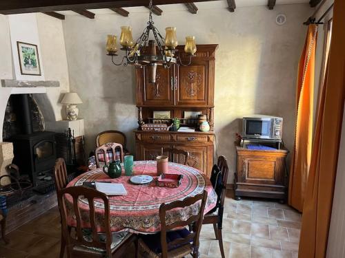 une salle à manger avec une table et un four micro-ondes dans l'établissement Maison cévenole typique et son jardin suspendu, à Lasalle