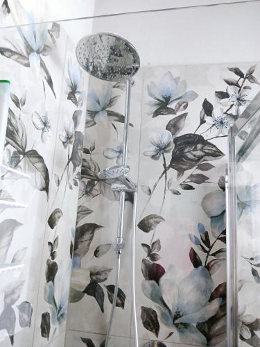 a shower curtain with blue flowers on a wall at Casa Mascia Pinna in Maracalagonis