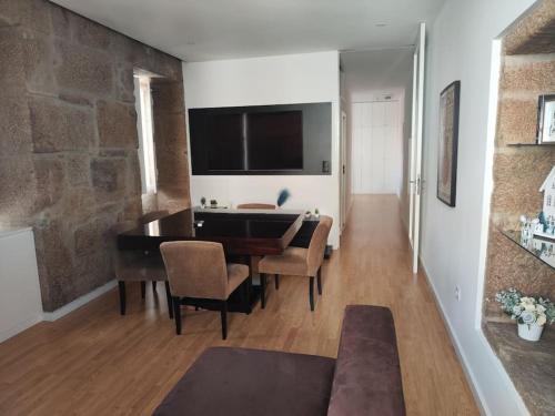 a living room with a dining room table with chairs at T2 duplex Avenida in Vila Real