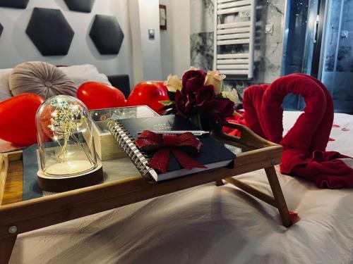 un lit avec une table avec un plateau avec une horloge et un bocal en verre dans l'établissement L'Olympe, à Chamalières