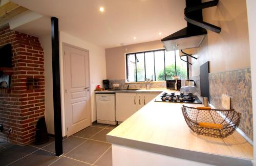 une cuisine avec un comptoir et un mur en briques dans l'établissement La Forge d'Espérance, à Éperlecques