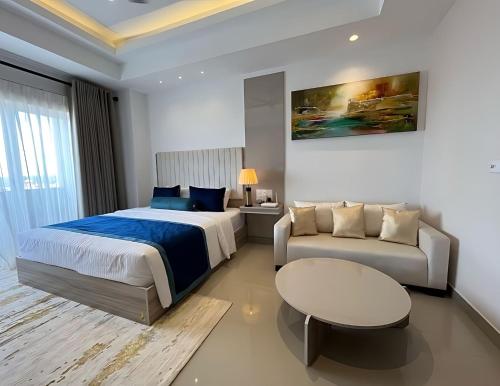 una camera con letto e divano di Negombo Bliss on the Beach Luxury Studios by Serendib Vacation a Negombo