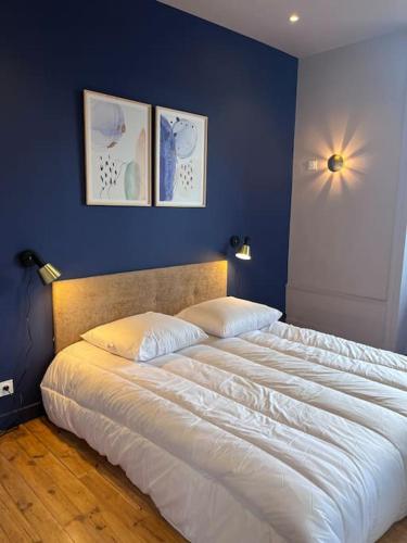 une chambre avec un grand lit blanc avec des murs bleus dans l'établissement Horus Elegant Gare SNCF 4p, à Clermont-Ferrand