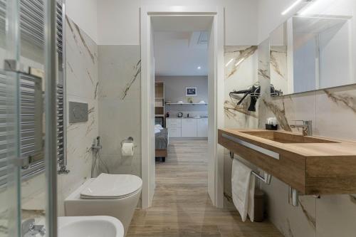 a white bathroom with a toilet and a sink at Villa Carducci in Comacchio