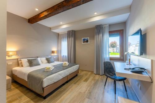 a bedroom with a bed and a desk and a window at Villa Carducci in Comacchio