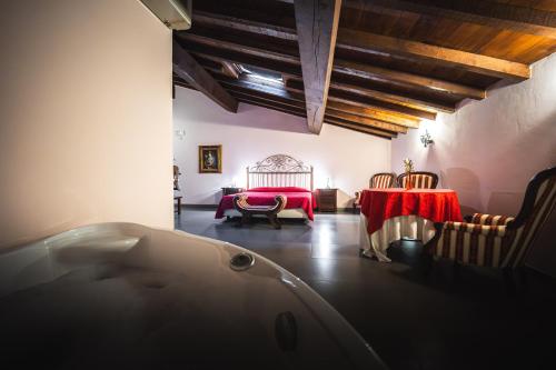 ein Bad mit einer Badewanne, einem Tisch und einem Bett in der Unterkunft Hotel La Tavola Rotonda in Cortemaggiore