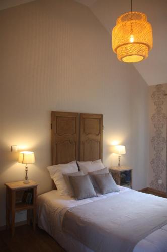 une chambre avec un lit blanc avec deux tables de nuit dans l'établissement La Forge d'Espérance, à Éperlecques