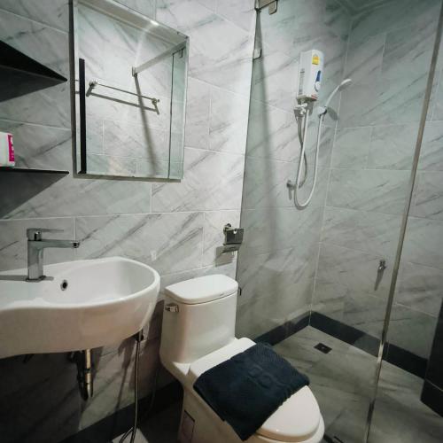 a bathroom with a shower and a toilet and a sink at Baan Thanakul Residences in Samutprakarn