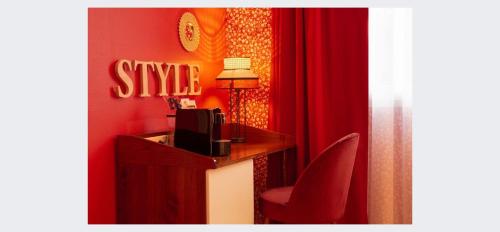 um quarto vermelho com uma secretária com uma televisão e uma cortina vermelha em Aiden by Best Western Paris Roissy CDG em Roissy-en-France