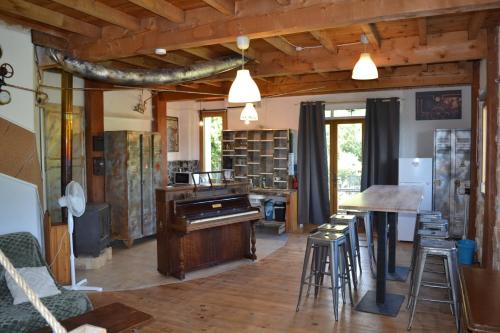 - un salon avec un piano et une table dans l'établissement Escape gîte de 4-6-8 pers avec jacuzzi entre Anduze et Alès, à Carnoulès