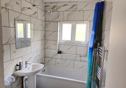 a bathroom with a sink and a tub and a mirror at PRIVATE ROOM In TOWN CENTRE FREE PARKING WI FI AND PATIO WITH AA STAY LTD in Buckinghamshire