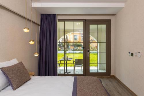 a hotel room with a bed and a sliding glass door at Ema Houses in Antalya