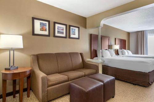 um quarto de hotel com uma cama e um sofá em Comfort Suites Grandville em Grandville