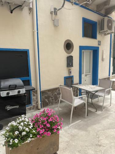 a patio with a table and chairs and a tv at Itaca in Lipari