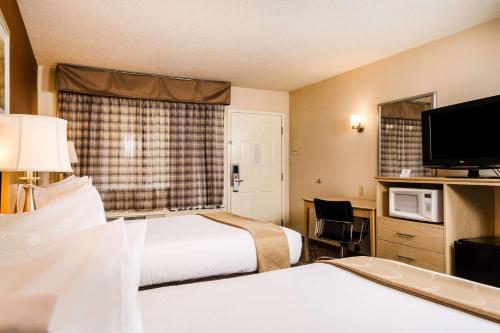 een hotelkamer met 2 bedden en een flatscreen-tv bij Quality Inn & Suites Lathrop in Lathrop