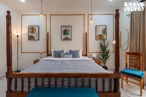 a bedroom with a bed and a blue chair at StayVista at Rio Vista with Pool, Lawn, Music Speaker & Game in Neral