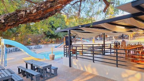 a park with a slide and a playground at Mabalel Lodge in Nelspruit