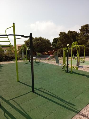 an empty playground with yellow equipment in a park at Luna e Mare in Cala Gonone